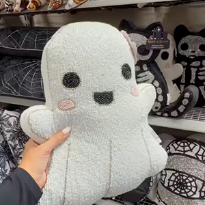 Woman’s hand holding boucle ghost pillow