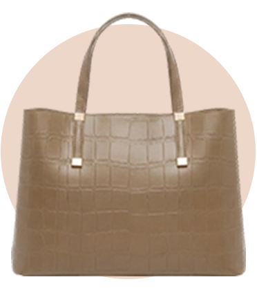 A khaki crocodile print tote bag against a beige circular background.