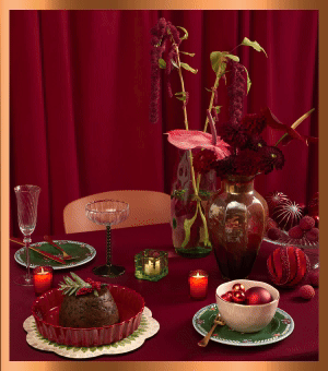 A Christmas tablescape with baubles, dinnerware and fresh flowers.