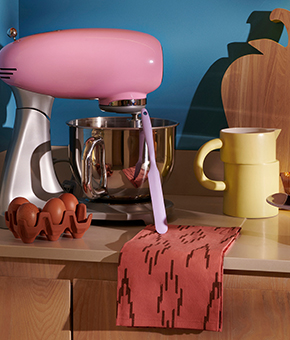 A curated selection of kitchen essentials from a printed tea towel to a butter yellow ceramic mug