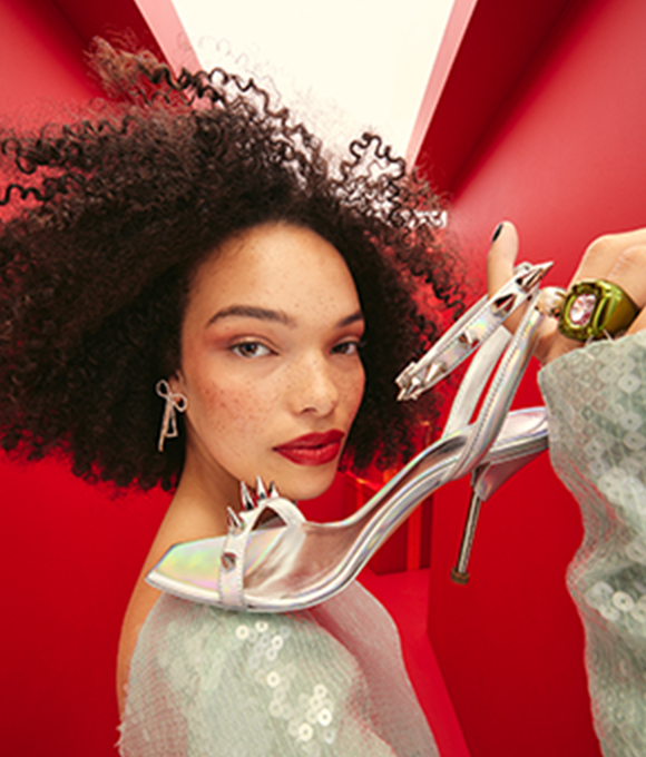 A model holding a pair of strappy heels