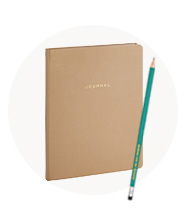 A tan notebook and green pencil.