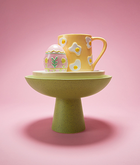 An egg-themed pot and jug are stacked inside pastel-hued serving bowls.