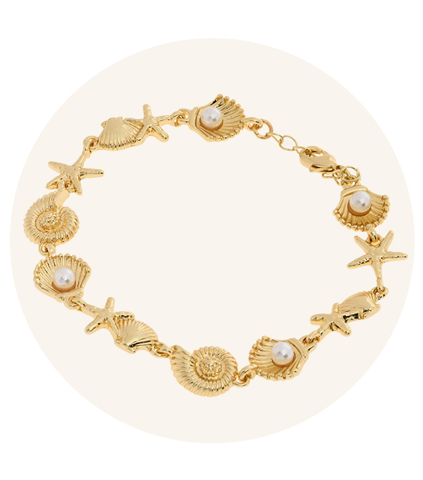 A gold necklace featuring delicate shell shapes and pearls. 