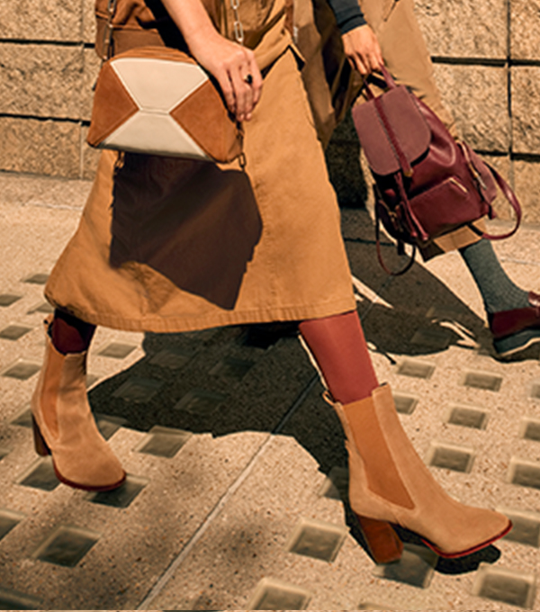 Tan trench coat, heeled ankle boots and handbags in autumnal colours.