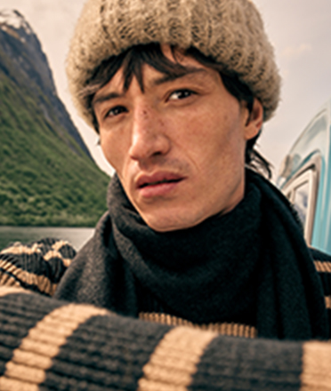 Man wearing knitted hat, scarf and jumper.