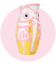 A fish-shaped vase that's painted in pastel hues.				