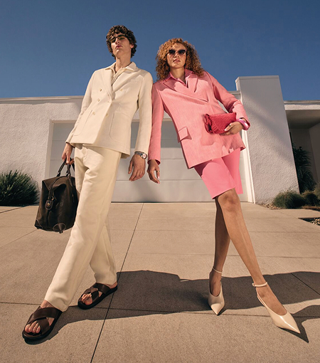 A man in a white suit and a women wearing a pink suit. 