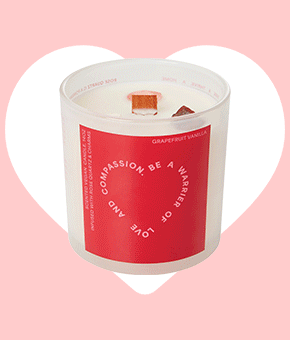 A large scented candle with a bold red label. 