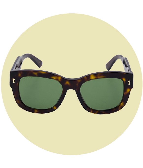 Tortoiseshell sunglasses with green lenses on a green circular background.				