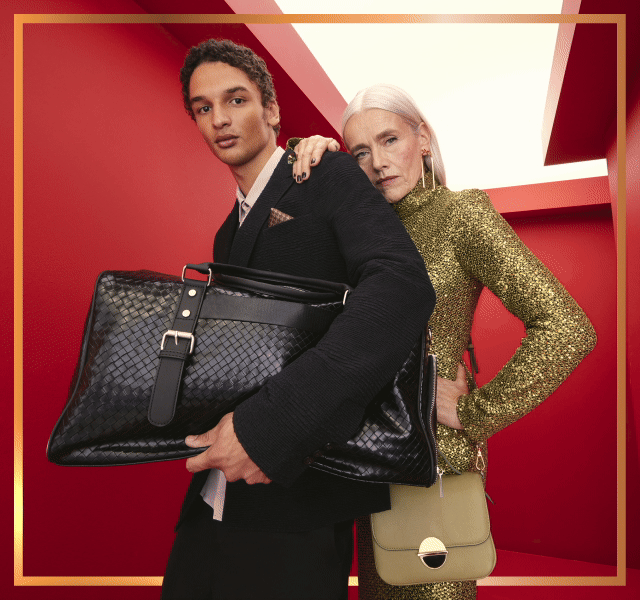 A male and female model wearing smart festive outfits including a tailored suit and sparkly dress. 