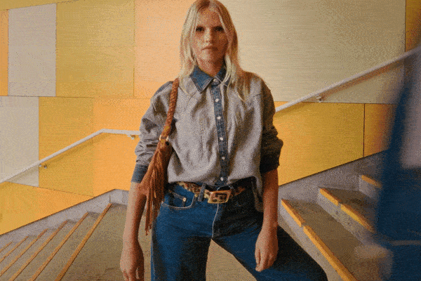 Four models stand on a busy staircase, each one wearing denim shirts and jackets.