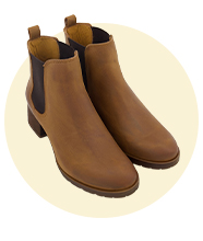 Pair of brown leather ankle boots with a low heel, elastic side panels, and pull tabs, shown against a neutral circular background.