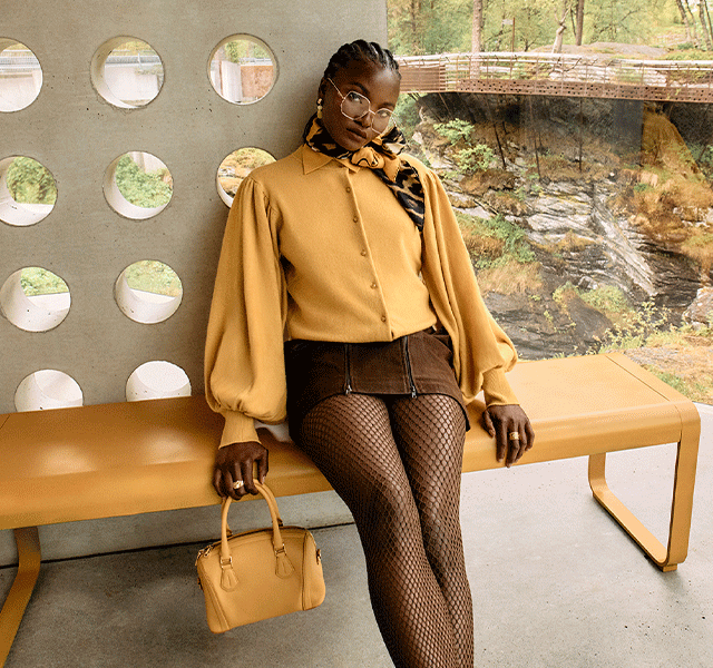 A female model wearing luxury outfits in a sleek, modern house 
