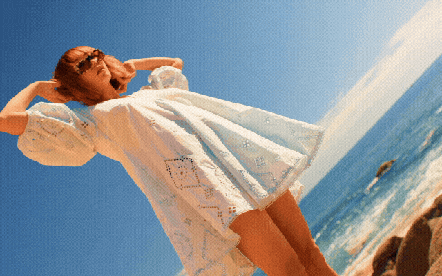 GIF of a man, woman and little girl on the beach in swimming gear and summer outfits.