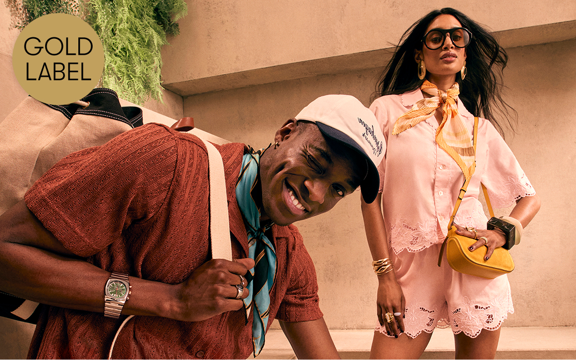 A male model wearing a cap and scarf, and a female model with a bag.
