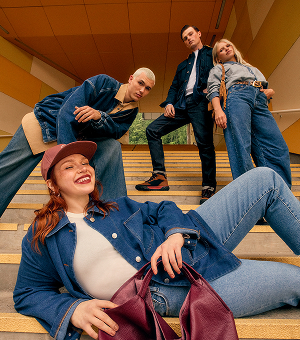 Smiling models wearing light and dark-toned denim jeans.