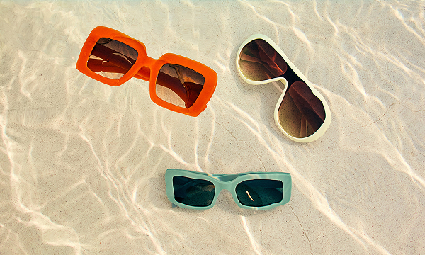 A trio of bright, bold sunnies on a sandy shore.