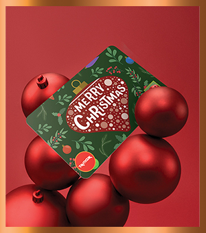 A gift card surrounded by large red baubles. 