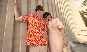 A man and woman in summery clothes bask in the sunshine.