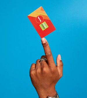 A model pointing to a TK & Homesense gift card against a blue background. 