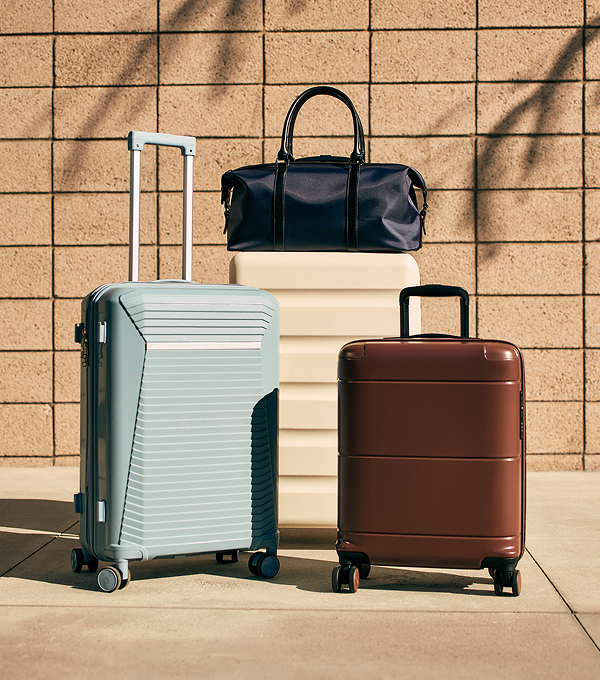 Three stylish suitcases, small, medium and large, pictured outside in the sun. 
